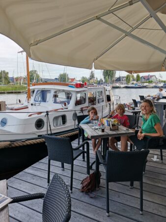 Frau mit zwei Kinder im Restaurant im Hintergrund ein Schiff