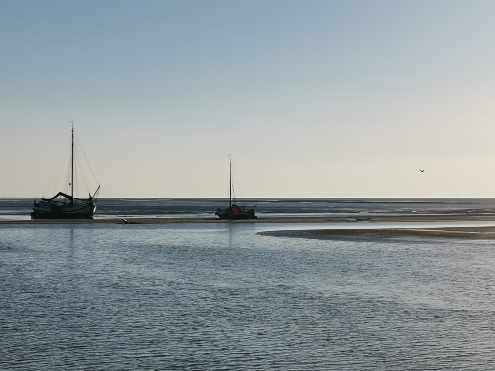 Zwei Schiffe liegen auf dem trockenen in der Waddensee