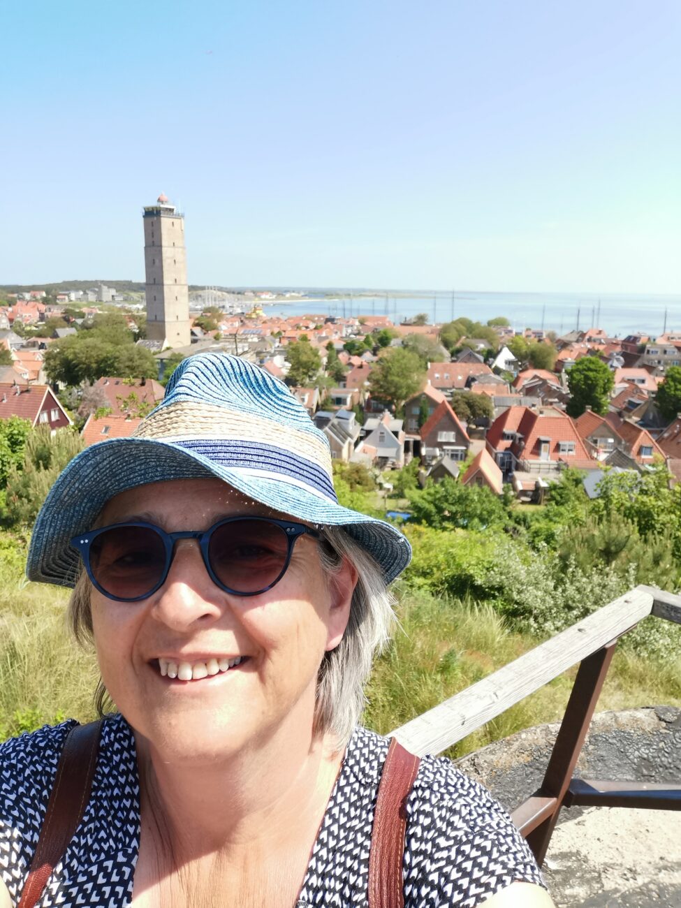 Selfie von Frau mit Hut, Stadt im Hintergrund