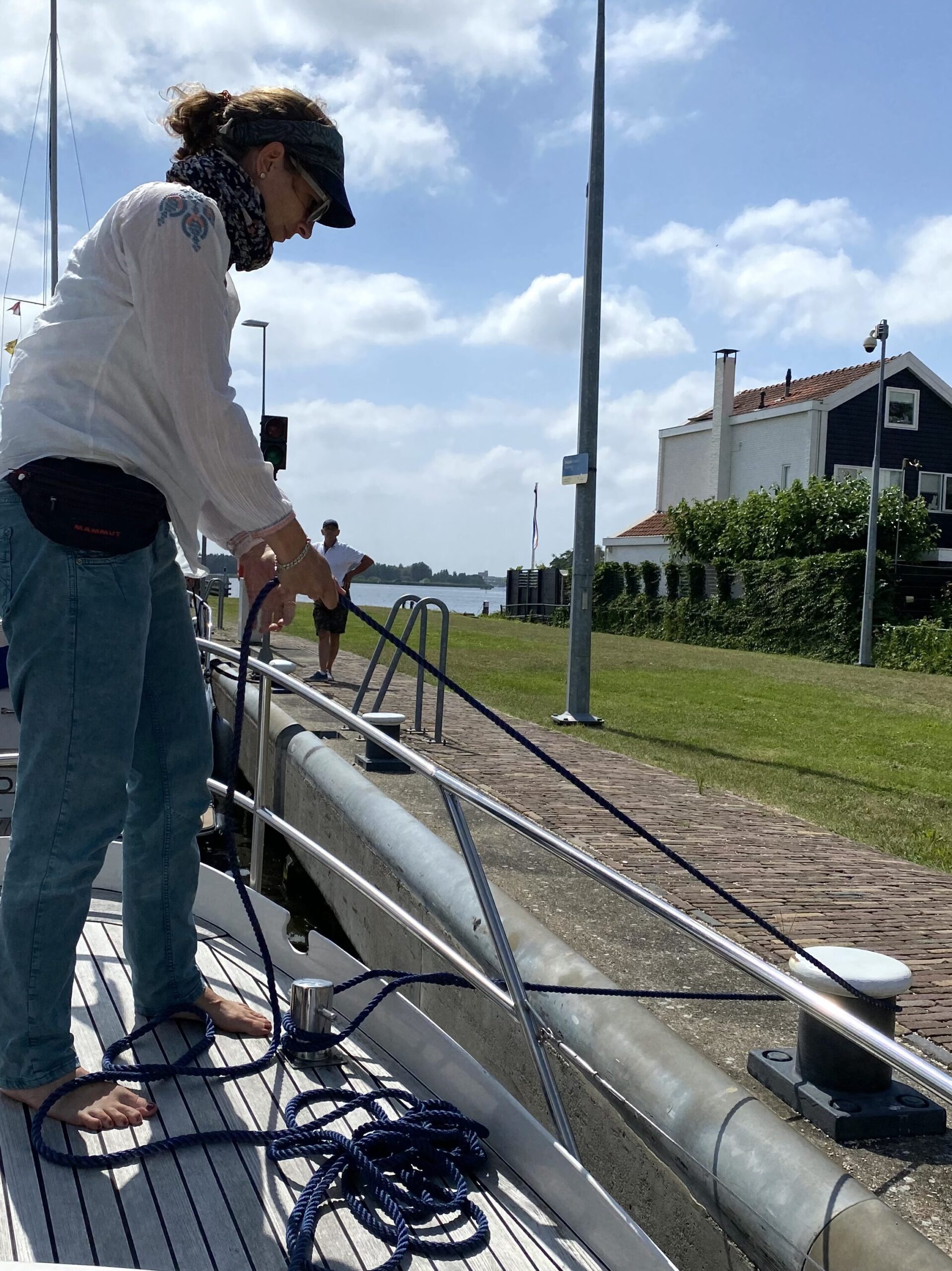 Frau hält mit Seil Boot am Ufer fest