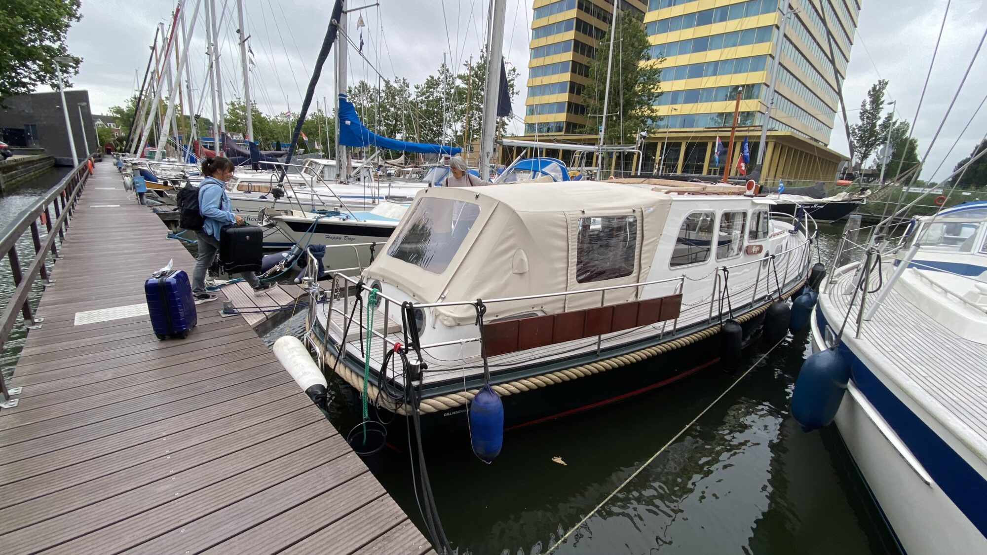 Frau besteigt mit Koffer Boot