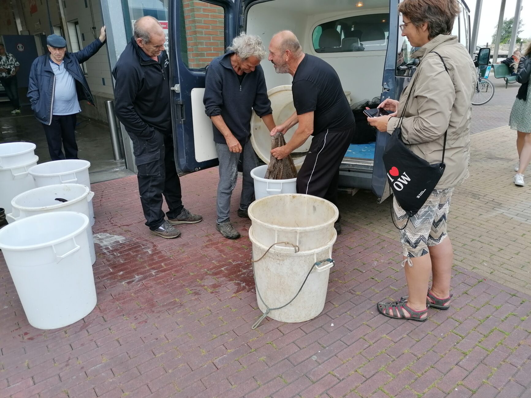 Männer füllen etwas in Kessel ab