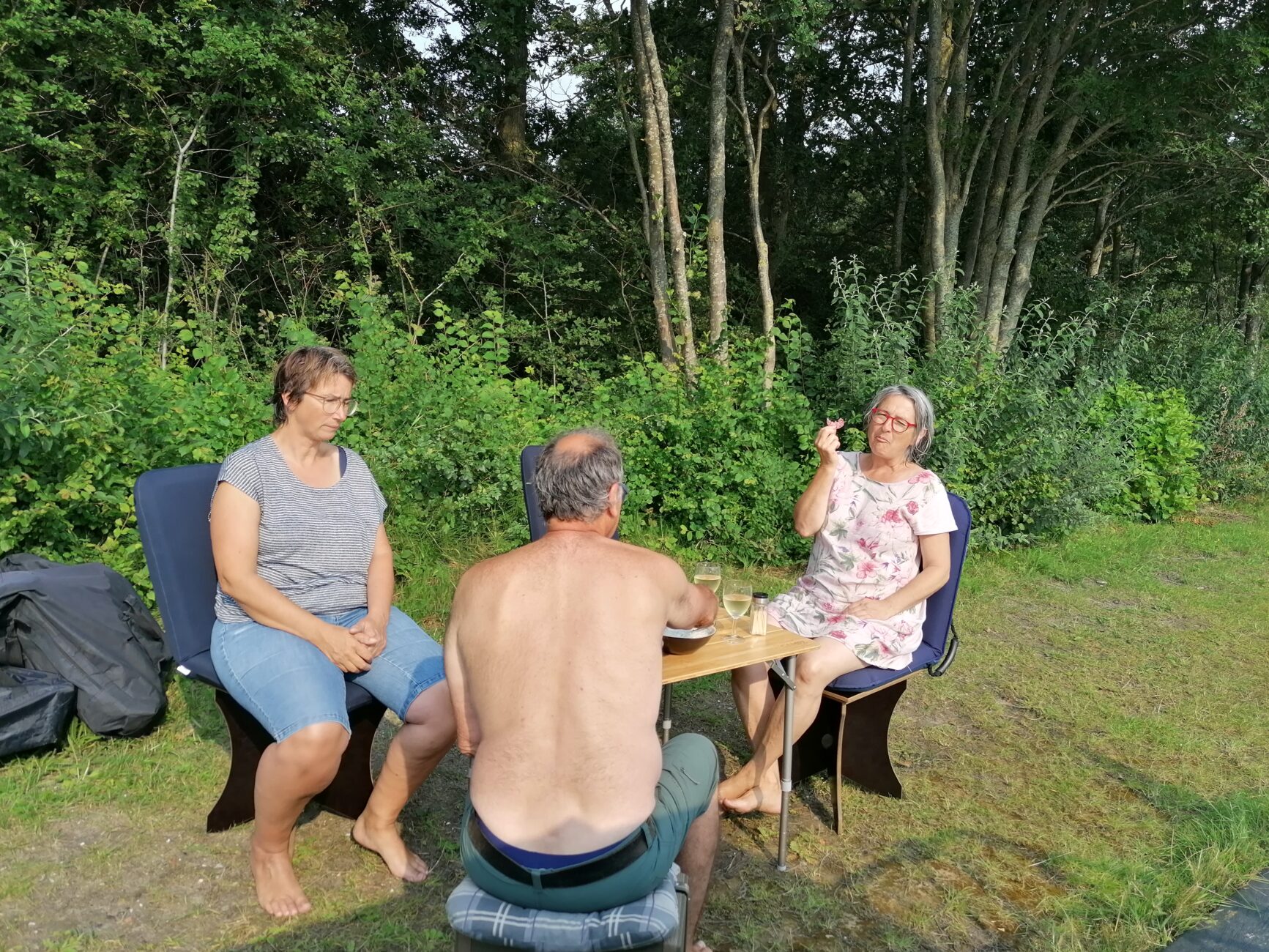 Drei Personen sitzen drausen beim Apero